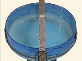 a blue glass bowl with a silver handle on a stand