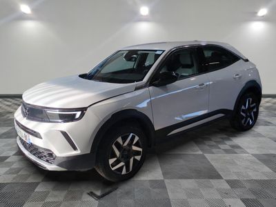 un 4x4 blanc garé sur un sol en damier dans un garage
