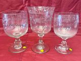 trois verres à vin vides posés sur une nappe rouge, sur fond rouge