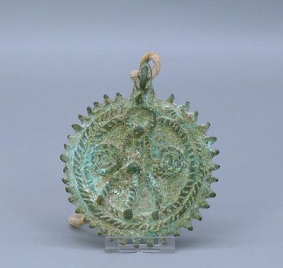 une image représentant un objet métallique vert posé sur une surface blanche