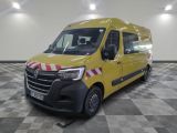 La camionnette jaune est garée dans une grande pièce au sol carrelé.