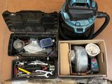 a box of tools sitting on the floor next to a vacuum