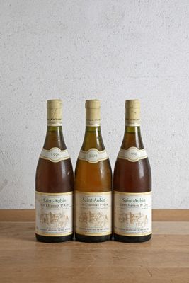 trois bouteilles de vin posées sur une table en bois