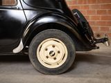 a black car parked in front of a brick wall