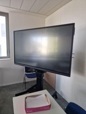 un téléviseur à écran plat posé sur un support dans le coin d'une pièce