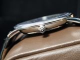 a watch sitting on top of a brown leather bag