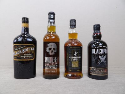 Trois bouteilles d'alcools différents sont alignées sur une table