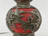 a red vase with a dragon on it on a table
