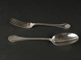 deux cuillères et une fourchette posées sur une table noire