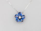 une photo d'un collier représentant une fleur bleue, orné d'un diamant au centre