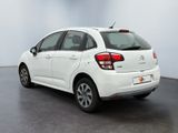 the rear end of a white citrole parked in a room