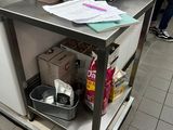 a kitchen island with a metal counter top and a bucket on it