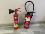 two fire extinguisors next to each other on the floor