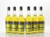quatre bouteilles de whisky sont alignées sur une surface blanche