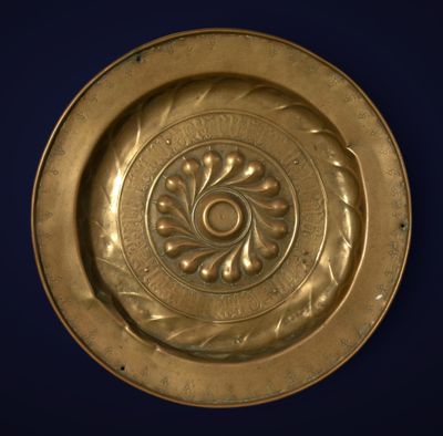 plaque en laiton ornée d'un motif circulaire sur fond bleu