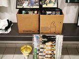 deux boîtes de nourriture et un verre de vin posés sur un banc