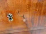 a close up of a wooden cabinet with a keyhole