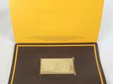 a close up of a gold bar in a box on a white surface