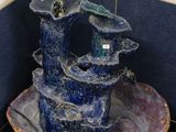 a blue bowl with a bird perched on top of it
