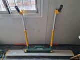 two brooms that are sitting on the floor next to a window