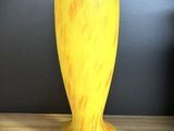 un vase jaune posé sur une table