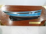 un bateau bleu et blanc sur une plaque en bois
