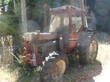 a red tractor that is parked in the grass