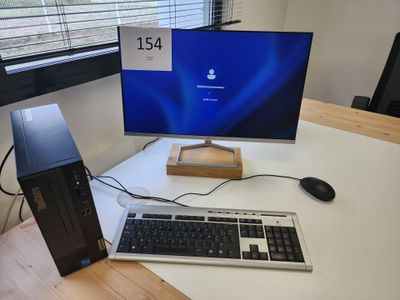 un ordinateur de bureau posé sur un bureau, à côté d'un écran d'ordinateur