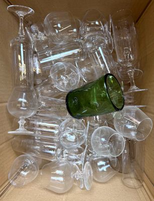 une boîte remplie de verres à vin vides, avec une bouteille à l'intérieur