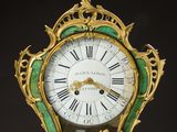 a gold and green clock with roman numerals on it