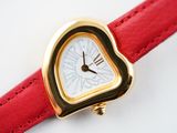 a heart shaped watch on a red leather strap