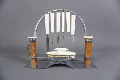 une assiette en argent sur laquelle sont posés cinq couteaux et une assiette sur laquelle sont posés cinq couteaux