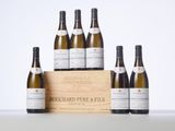 a group of six bottles of wine sitting next to a wooden box