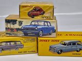 three boxed toy cars sitting on top of each other on a white surface