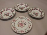 quatre assiettes ornées de motifs floraux sont disposées sur une table