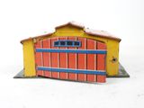 un petit bâtiment jaune et rouge avec une porte bleue