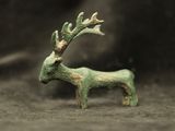 une petite figurine représentant un cerf, posée par terre