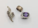 two rings and a ring with a purple stone on a white surface