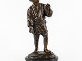 une statue en bronze représentant un homme tenant une batte de baseball