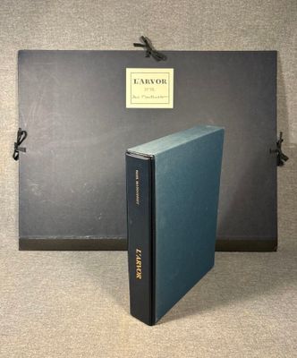 a blue book sitting on top of a table next to a black box
