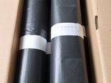deux rouleaux de plastique noir posés dans une boîte en carton sur une table
