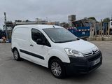 La camionnette blanche est garée sur un parking près d'un chantier.
