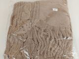 a brown blanket wrapped in plastic on a white table
