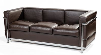 brown leather sofa with chrome legs and arm rests against a white background