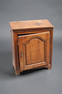 une vieille armoire en bois avec une porte et un tiroir sur le dessus