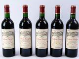 quatre bouteilles de vin sont alignées sur une surface blanche