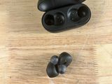 a pair of ear buds sitting on a wooden table