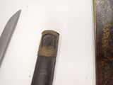 two different types of knives on a white surface