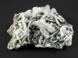 un gros plan d'une pierre recouverte de cristaux blancs sur fond noir