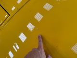 a person pointing at a yellow car with white squares on it